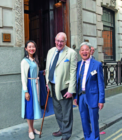 Ms Yuri, Michael Sefi LVO RDP FRPSL, former Keeper of the Royal Philatelic Collection, and Jack Zhang FRPSL look excited before stepping in. 